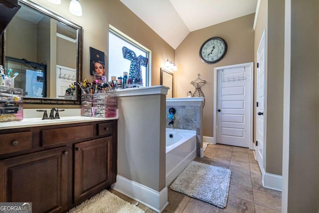 bathroom featuring a bath, vanity, and vaulted ceiling