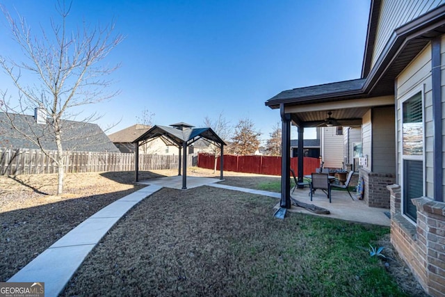 view of yard featuring a gazebo, ceiling fan, and a patio