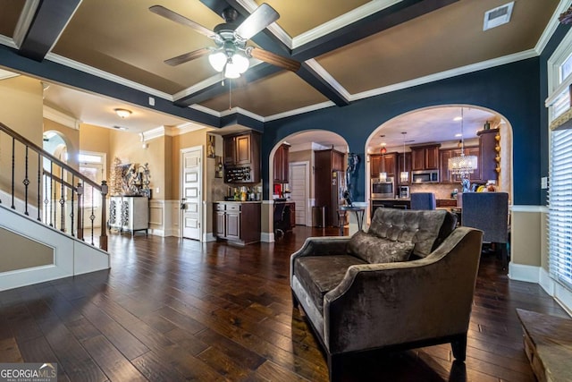 living room with ornamental molding, ceiling fan with notable chandelier, dark hardwood / wood-style floors, and a healthy amount of sunlight