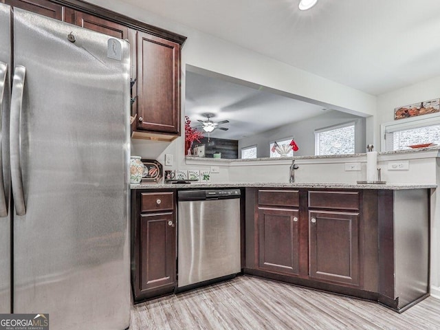 kitchen featuring appliances with stainless steel finishes, light wood-type flooring, dark brown cabinetry, and ceiling fan