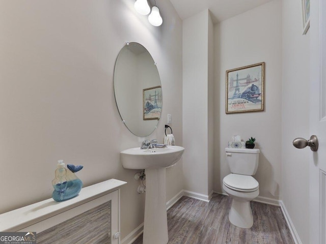 bathroom with hardwood / wood-style flooring, toilet, and sink