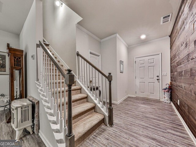 entrance foyer with hardwood / wood-style flooring and crown molding