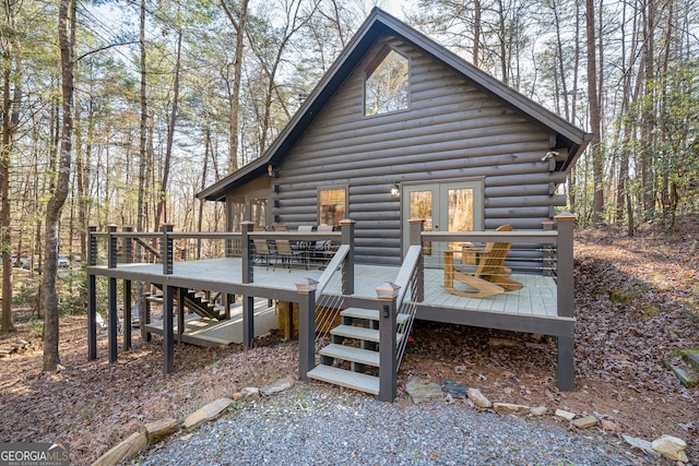 back of property featuring log siding, a wooden deck, and stairway