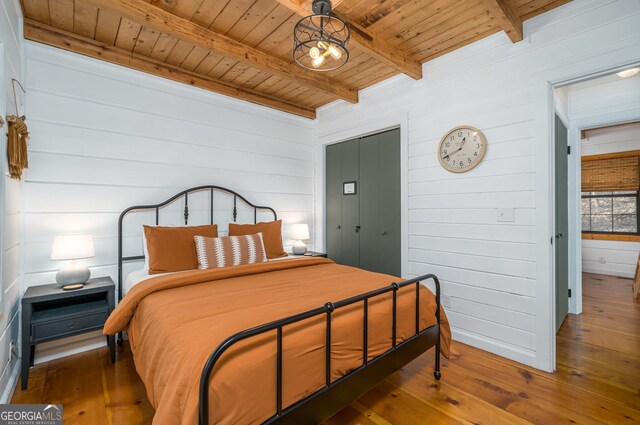 bedroom with beam ceiling, multiple windows, wooden ceiling, and wood-type flooring