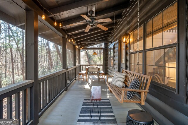 sunroom / solarium with vaulted ceiling with beams, ceiling fan, and wooden ceiling