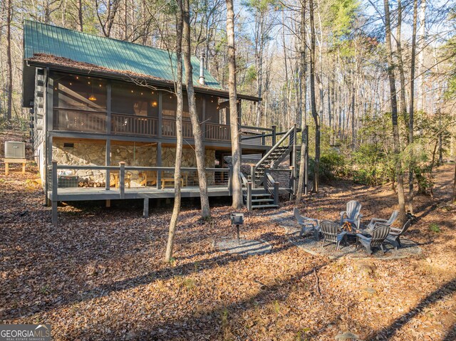 rear view of property with a deck and a sunroom