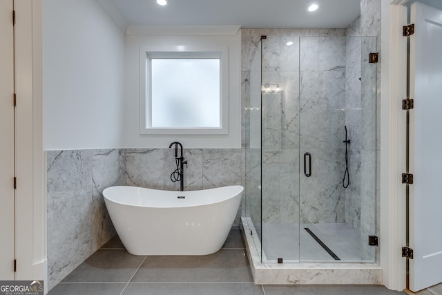 bathroom featuring tile patterned floors, separate shower and tub, and tile walls