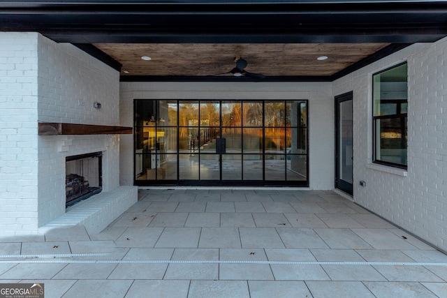 view of patio / terrace featuring ceiling fan and an outdoor brick fireplace