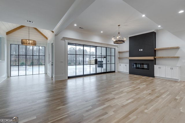 unfurnished living room featuring a fireplace, beamed ceiling, and light hardwood / wood-style flooring