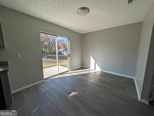 unfurnished room with a textured ceiling and dark wood-type flooring