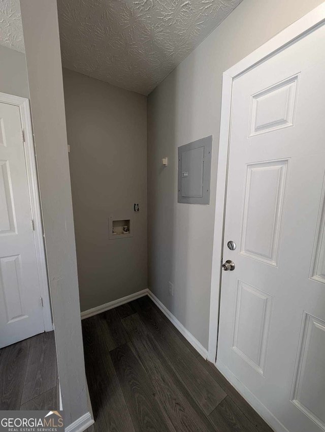 laundry area featuring a textured ceiling, electric panel, hookup for a washing machine, and dark hardwood / wood-style floors