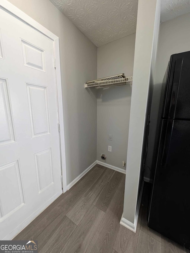 laundry area with hardwood / wood-style floors and a textured ceiling