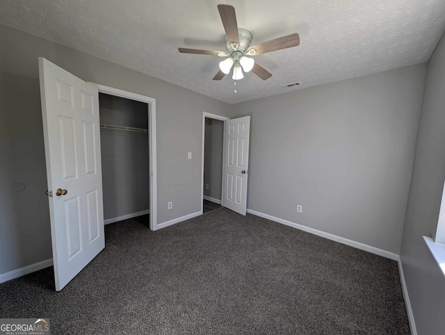 unfurnished bedroom with ceiling fan, a closet, dark carpet, and a textured ceiling