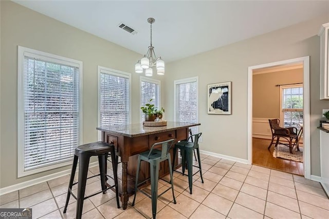 tiled dining area featuring an inviting chandelier