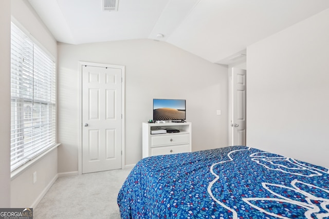 bedroom with carpet flooring, multiple windows, and lofted ceiling