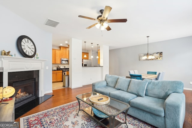 living room with ceiling fan and light hardwood / wood-style floors