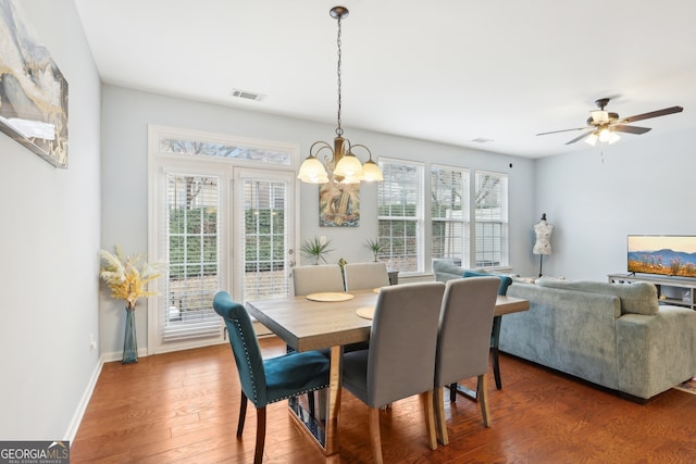 dining space featuring plenty of natural light, dark wood-type flooring, and ceiling fan with notable chandelier