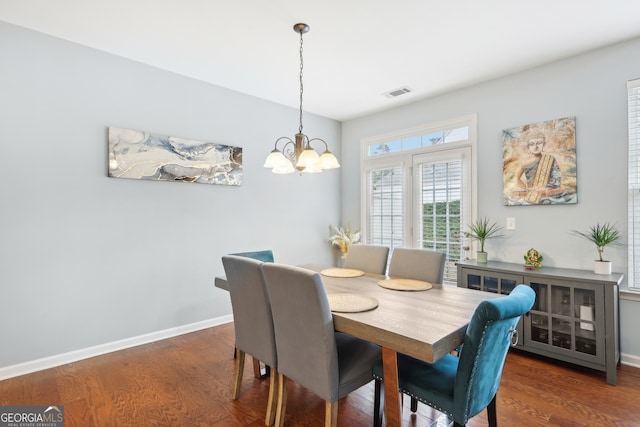 dining space featuring a notable chandelier and dark hardwood / wood-style floors