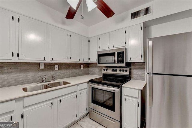 kitchen with white cabinets, light tile patterned floors, sink, and appliances with stainless steel finishes