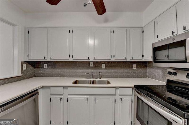 kitchen with white cabinetry, sink, ceiling fan, stainless steel appliances, and backsplash