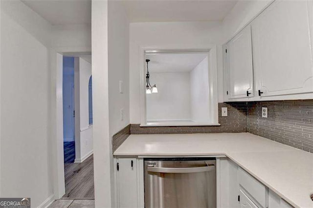 kitchen featuring white cabinets, light wood-type flooring, tasteful backsplash, and stainless steel dishwasher