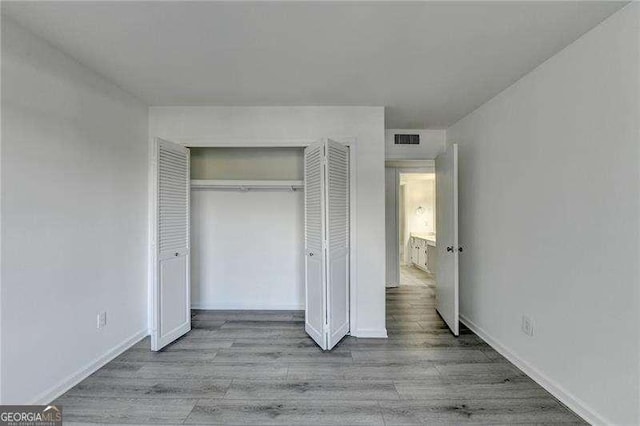 unfurnished bedroom featuring a closet and light hardwood / wood-style flooring