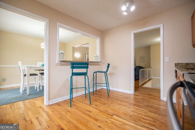 kitchen featuring light stone countertops, light wood-type flooring, and electric range