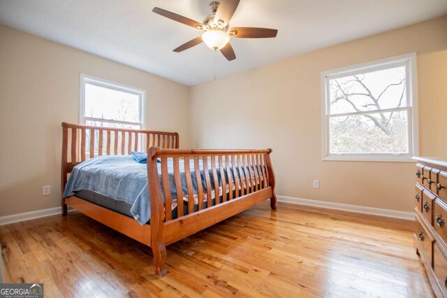 bedroom with multiple windows, ceiling fan, and light hardwood / wood-style flooring