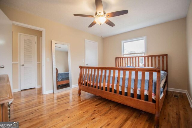 bedroom featuring ceiling fan, a closet, and light hardwood / wood-style floors