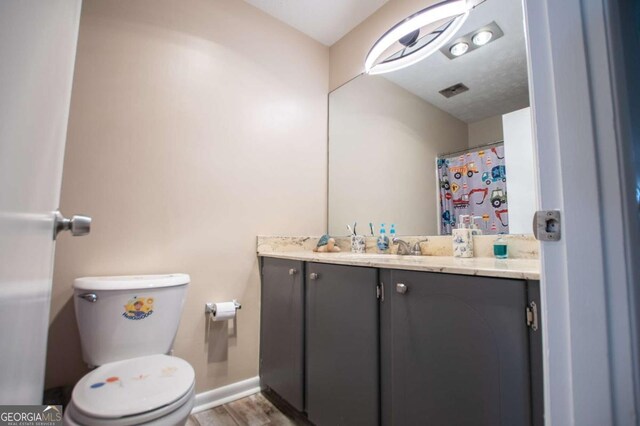 bathroom featuring wood-type flooring, vanity, and toilet