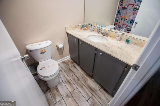 bathroom with hardwood / wood-style floors, vanity, and toilet