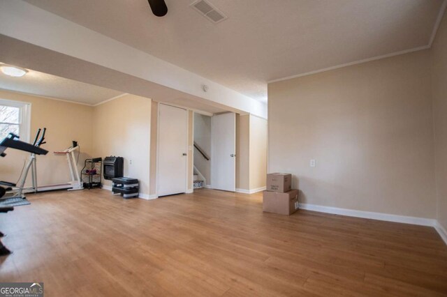 workout room featuring crown molding and hardwood / wood-style floors