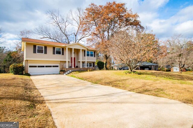 bi-level home featuring a porch, a garage, and a front lawn