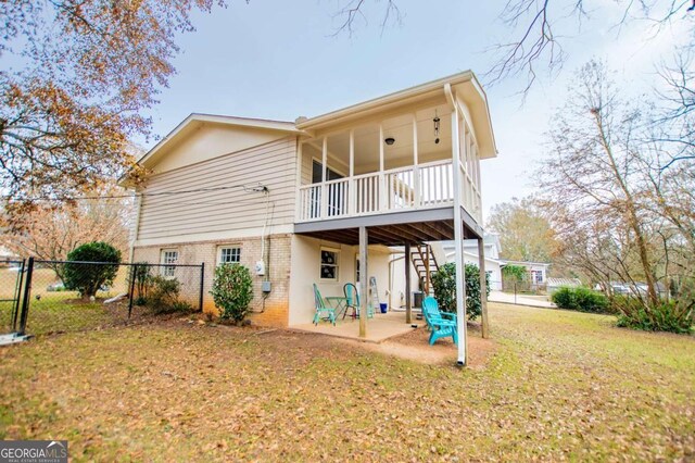 rear view of property with a lawn and a patio