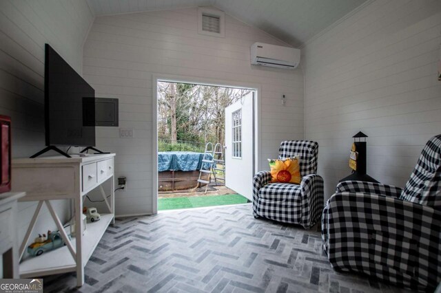 sitting room featuring an AC wall unit, wood walls, and high vaulted ceiling