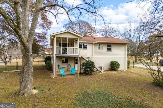 rear view of property featuring a yard