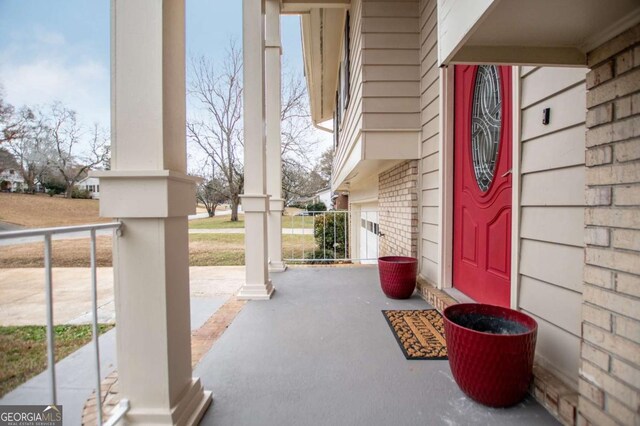 property entrance featuring a porch and a garage