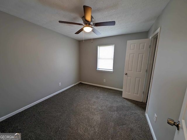 unfurnished room featuring dark colored carpet, a textured ceiling, and ceiling fan