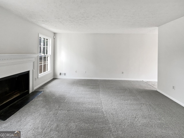 unfurnished living room with dark carpet and a textured ceiling