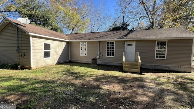 back of house with a lawn and central AC