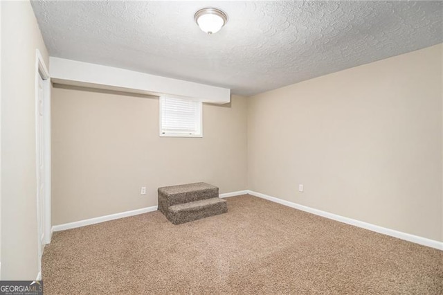 basement with carpet flooring and a textured ceiling