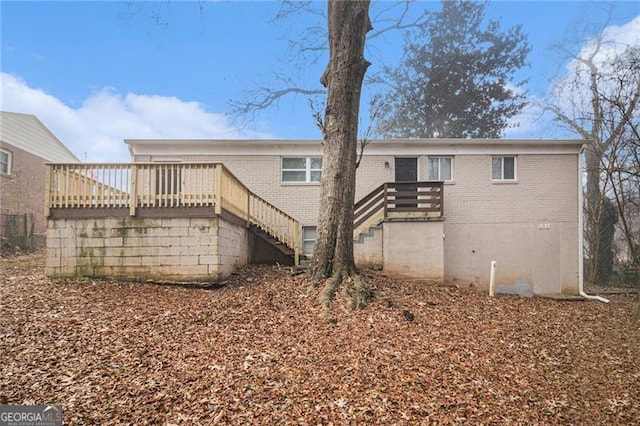 rear view of property featuring a wooden deck