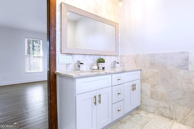 bathroom with vanity and tile walls