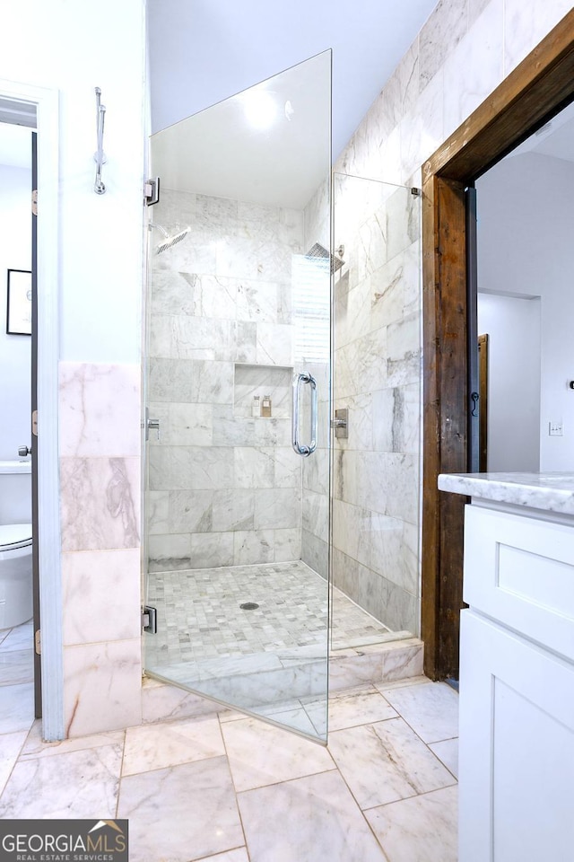 bathroom featuring vanity, toilet, and a shower with shower door