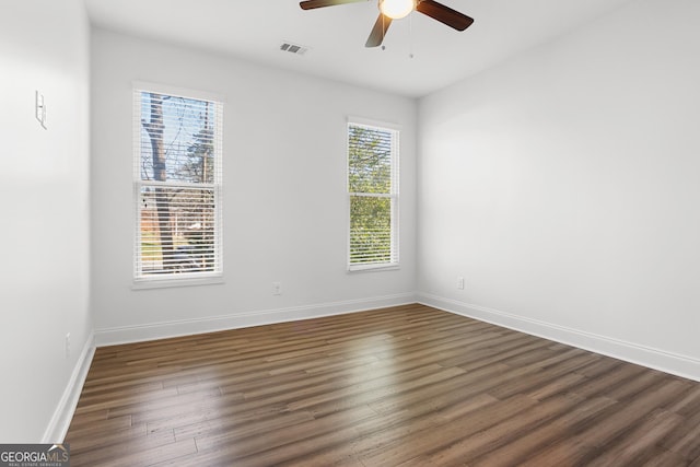 spare room with ceiling fan, a healthy amount of sunlight, and dark hardwood / wood-style flooring