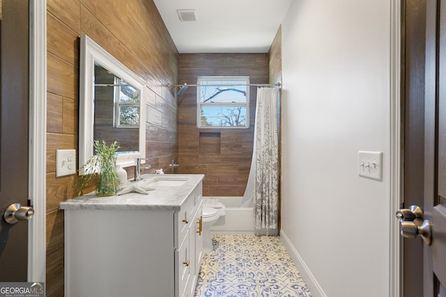 full bathroom featuring vanity, wooden walls, tile patterned flooring, toilet, and shower / tub combo