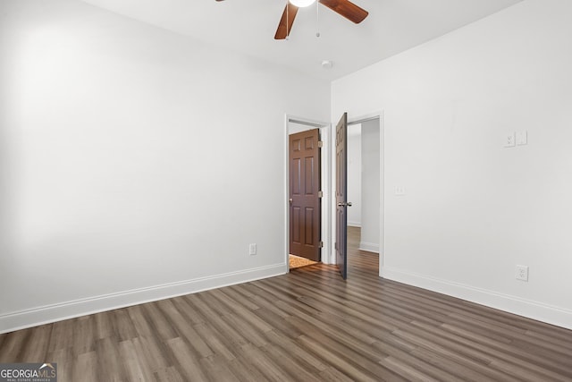 unfurnished room with ceiling fan and dark wood-type flooring