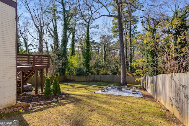 view of yard featuring a deck and a fire pit