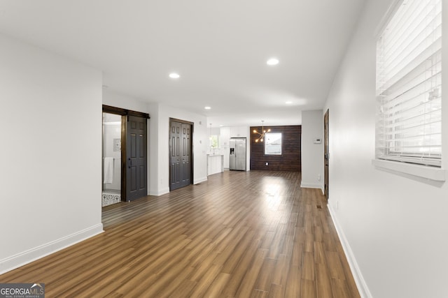 unfurnished living room featuring a barn door and dark hardwood / wood-style floors