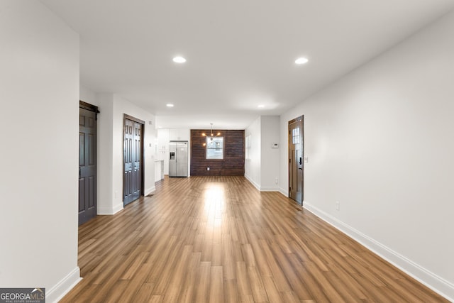 unfurnished living room featuring hardwood / wood-style floors and a barn door